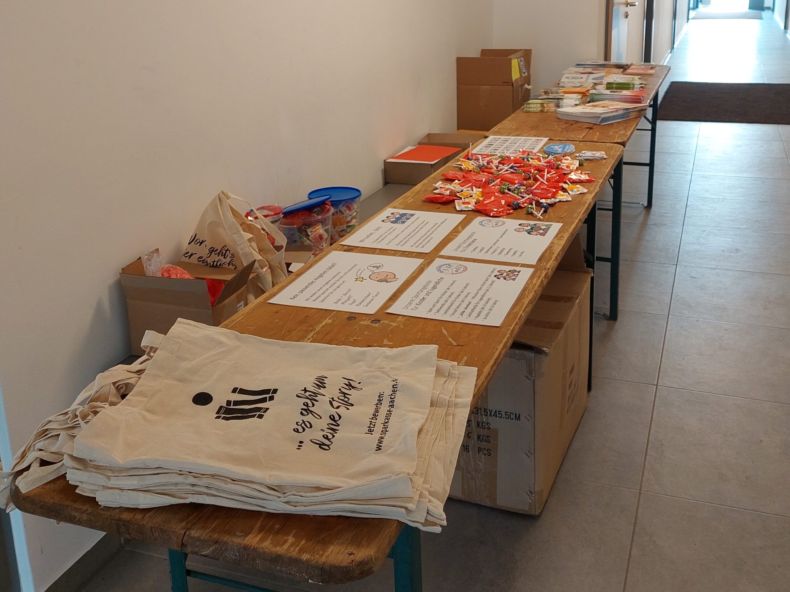 Ein langer Tisch mit Give-Aways und Info-Material.